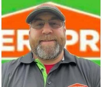 Construction manager in front of SERVPRO van