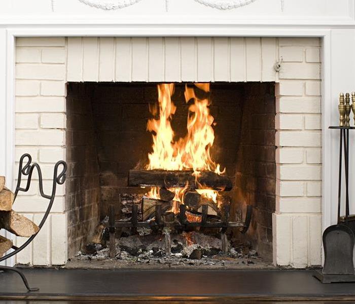 cozy brick fireplace with a fire burning 