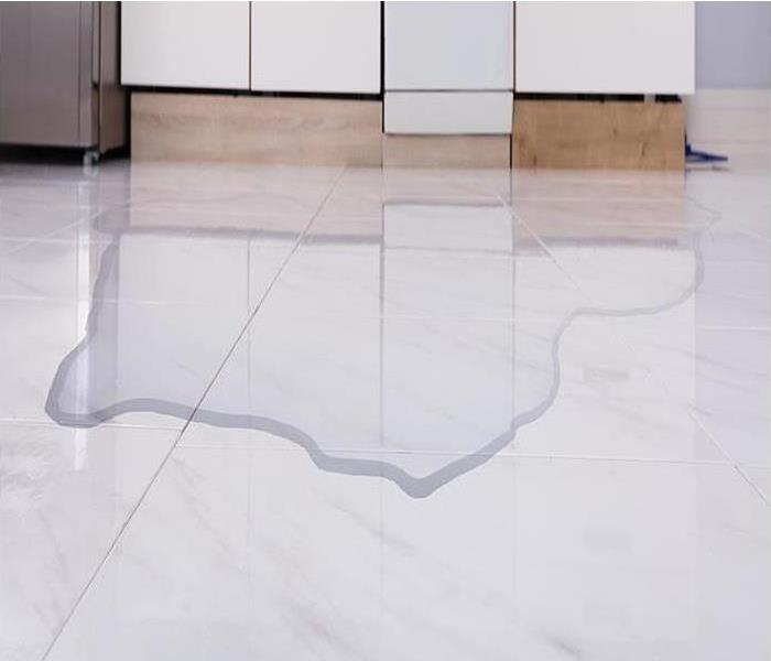 A white tile floor with water on it.